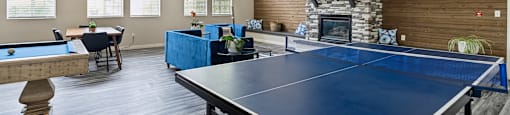 a game room with a ping pong table and a fireplace