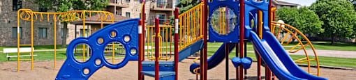 A playground with a blue slide and a yellow and blue climbing structure.