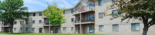 A large apartment complex with a green lawn in front.