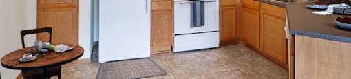 A kitchen with a white refrigerator and white stove.
