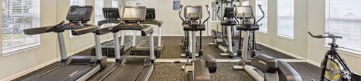 a gym with treadmills and exercise bikes on the floor