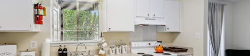 a kitchen with white cabinets and appliances and a sink