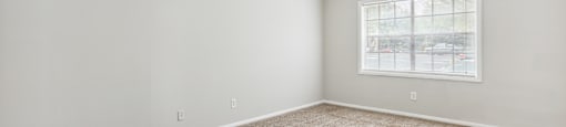 an empty room with carpet and a window