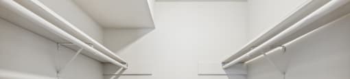 an empty room with white walls and two white racks on the wall