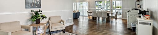 the living room and dining area of a home with a wood floor and white walls