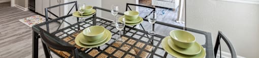 a dining room with a glass table and chairs