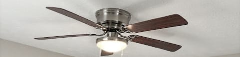 A room with a ceiling fan and two doors.