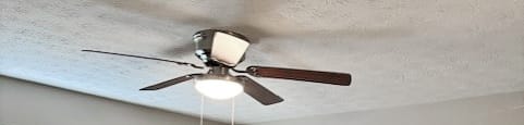A room with a ceiling fan and carpeted floor.