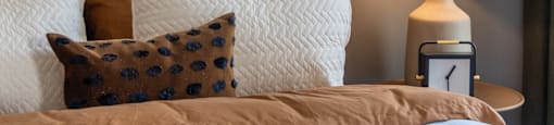 a bedroom with a bed and pillows and a lamp