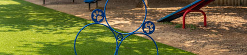 a blue sculpture in the shape of a bike in a park