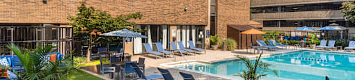 a swimming pool with lounge chairs and a building in the background