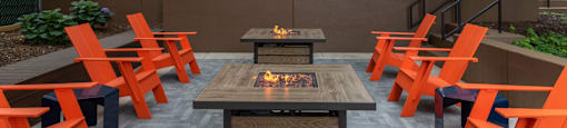 an outdoor patio with a fire table and orange chairs