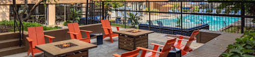 a patio with tables and chairs near a swimming pool
