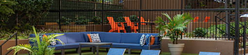 a seating area with blue chairs and a lawn