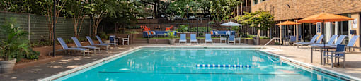 a swimming pool at a hotel with a building in the background