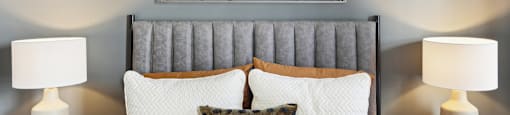 a bedroom with a bed with pillows and a painting on the wall