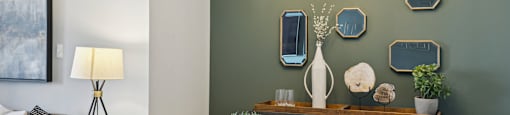 a dining room with a table and chairs and a wall with mirrors