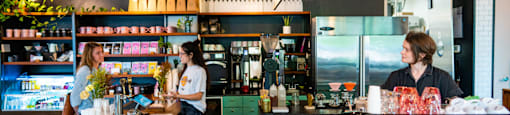 A woman is standing behind a counter in a restaurant.