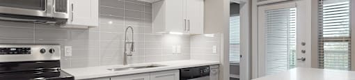 Apartment kitchen with white cabinets at The Can Plant Residences at Pearl, San Antonio, TX 78215and a white counter top  at The Can Plant Residences at Pearl, San Antonio, TX