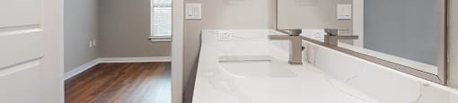 Apartment bathroom with a sink and a mirror at The Can Plant Residences at Pearl, San Antonio, TX 78215and a white counter top  at The Can Plant Residences at Pearl, San Antonio, TX
