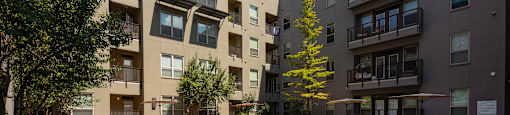 an apartment swimming pool in front of an apartment building at The Can Plant Residences at Pearl, San Antonio
