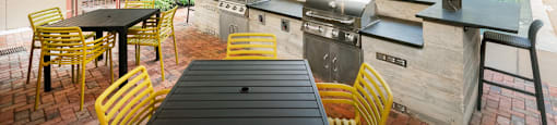 Outdoor patio with a pool and tables and chairs at The Can Plant Residences at Pearl, San Antonio, TX 78215and a white counter top