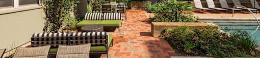 Courtyard with a pool and lounge chairs at The Can Plant Residences at Pearl, San Antonio, TX 78215
