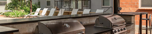 utdoor grill area with chairs and stainless steel appliances  at The Can Plant Residences at Pearl, San Antonio, TX