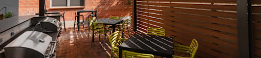Patio with tables and chairs and a TV at The Can Plant Residences at Pearl, San Antonio, TX 78215