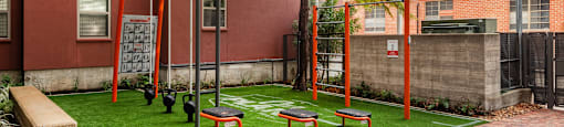 A playground with grass and bench at  The Can Plant Residences at Pearl, San Antonio, TX 78215