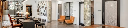 a large room with a table and chairs and a lobby at The Can Plant Residences at Pearl, San Antonio, 78215