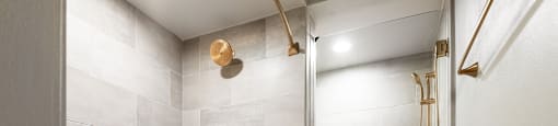 A bathroom with a white tub and grey tiles.