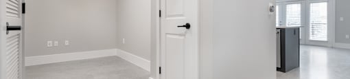 A spacious room with a ceiling fan and a door.