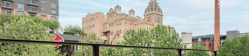 A view from a balcony overlooking a courtyard with a building in the background.