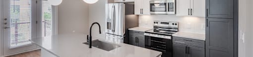 A modern kitchen with a large island and stainless steel appliances.