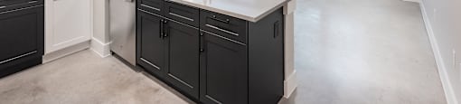 A kitchen with black cabinets and a white countertop.