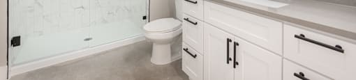 A white bathroom with a walk-in shower and a toilet.