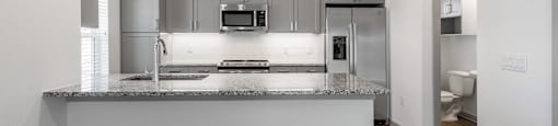 an empty kitchen with a granite counter top and
