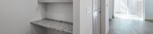 the living room and hallway of an apartment with white walls and wood flooring