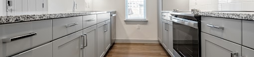 a kitchen with white cabinets and stainless steel appliances