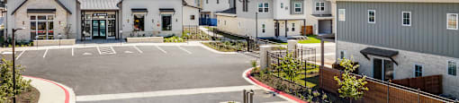 an empty parking lot in front of a row of houses