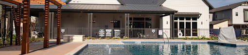 a large pool in front of a house with a blue sky