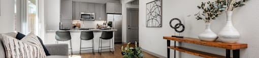 a living room with a couch and a coffee table in front of a kitchen