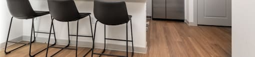a kitchen with a large island with three chairs