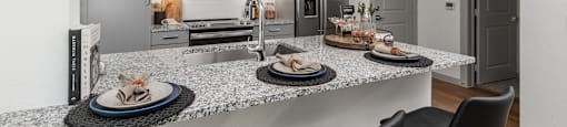 a kitchen with granite counter tops and a island with plates of food