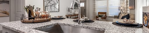 an open kitchen with granite counter tops and a sink