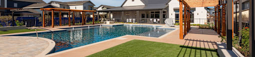 a large swimming pool with a house in the background