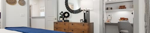a bedroom with a bed and a desk and a mirror