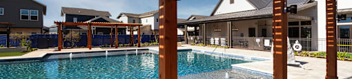a swimming pool with a wooden structure in front of a house