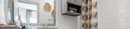 a bathroom with gray cabinets and a toilet and a shower curtain